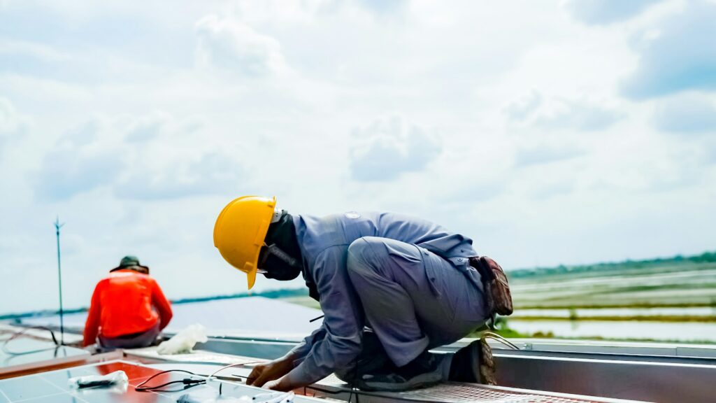 Engineers installing solar panels on roof.