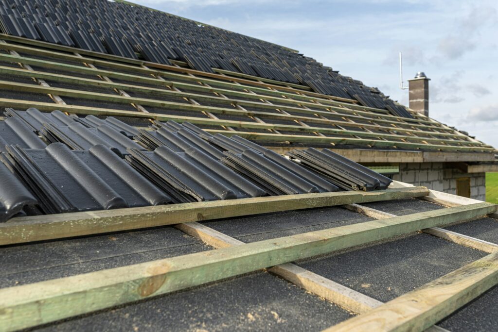 Roof ceramic tile arranged in packets on the roof on roof battens. laying tiles on a boarded roof.